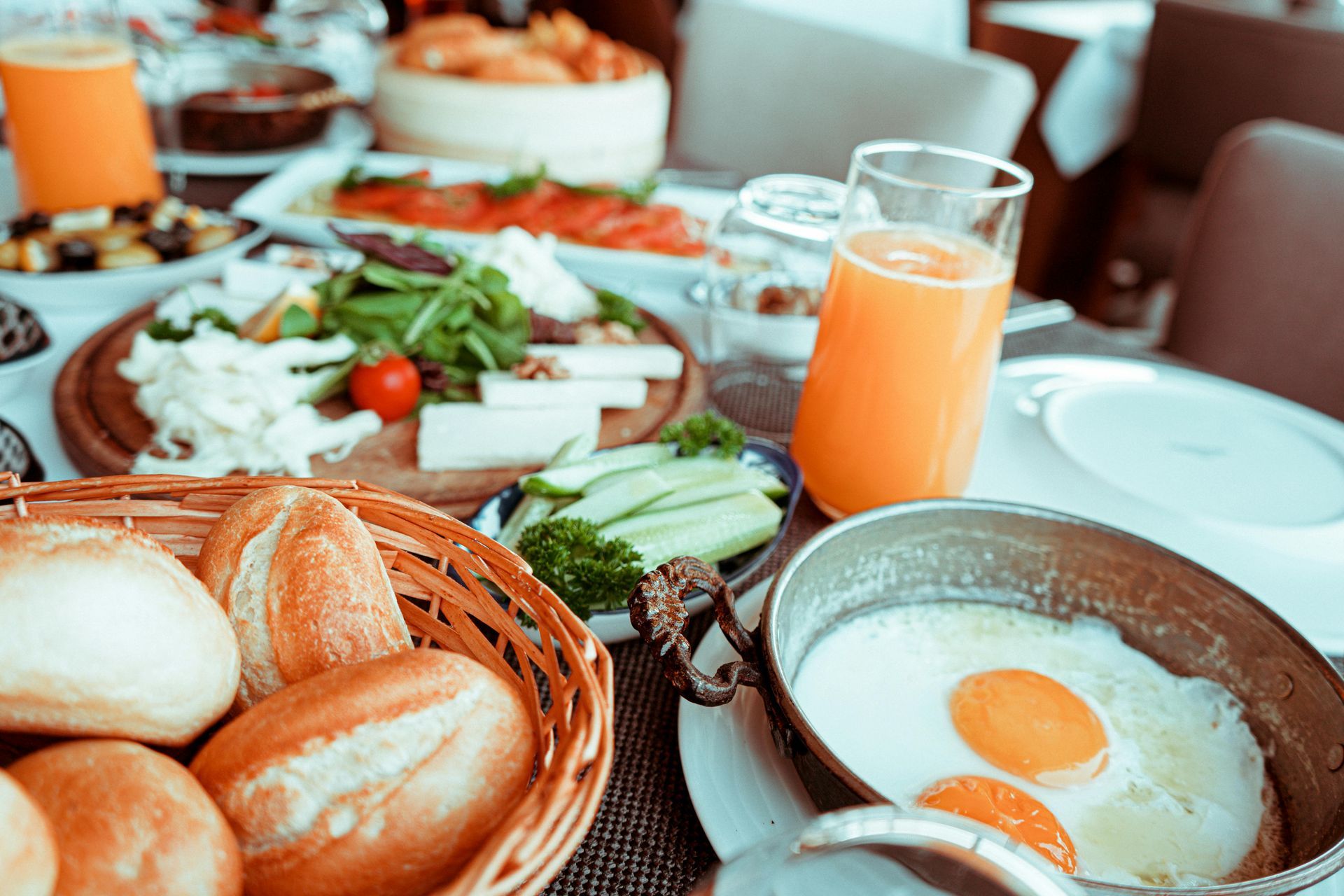 Istanbul By Rich Hotel | Breakfast table laden with bread, cheese, eggs, juice, and other assorted dishes.