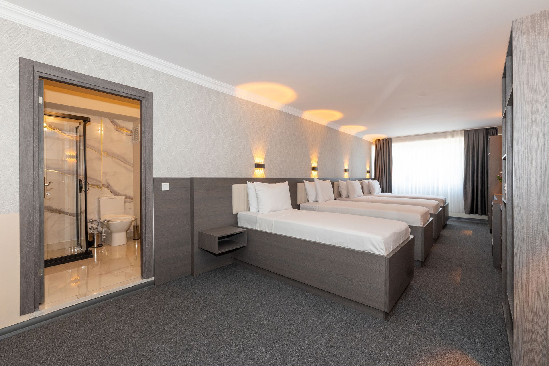 Istanbul By Rich Hotel | Hotel room with three single beds, a bathroom visible, and neutral-colored walls.