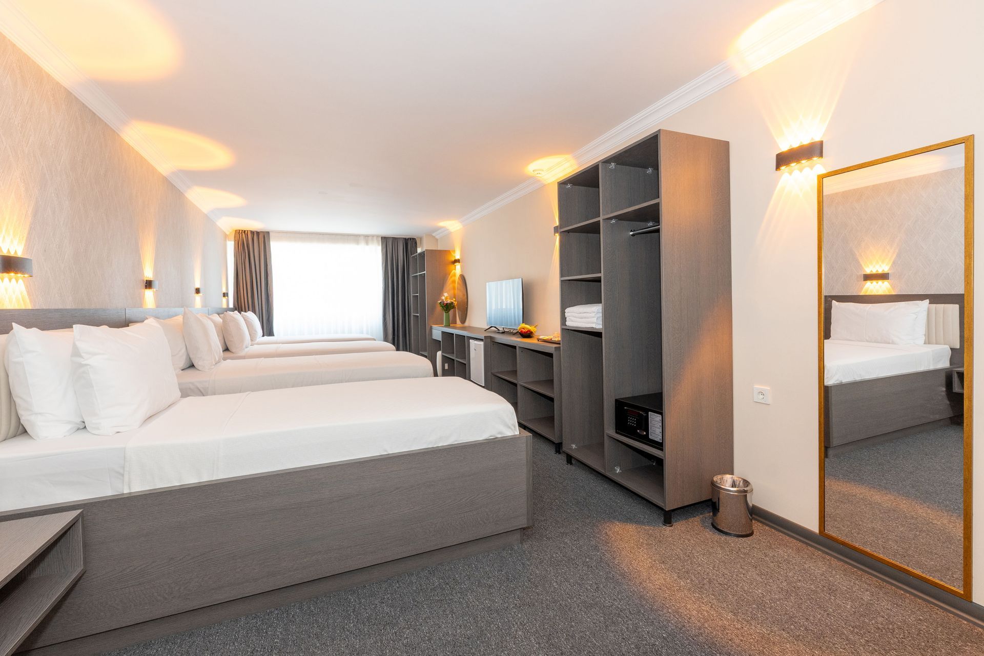 Istanbul By Rich Hotel | Triple Room | Hotel room with three beds, gray furniture, a large mirror, and a window.