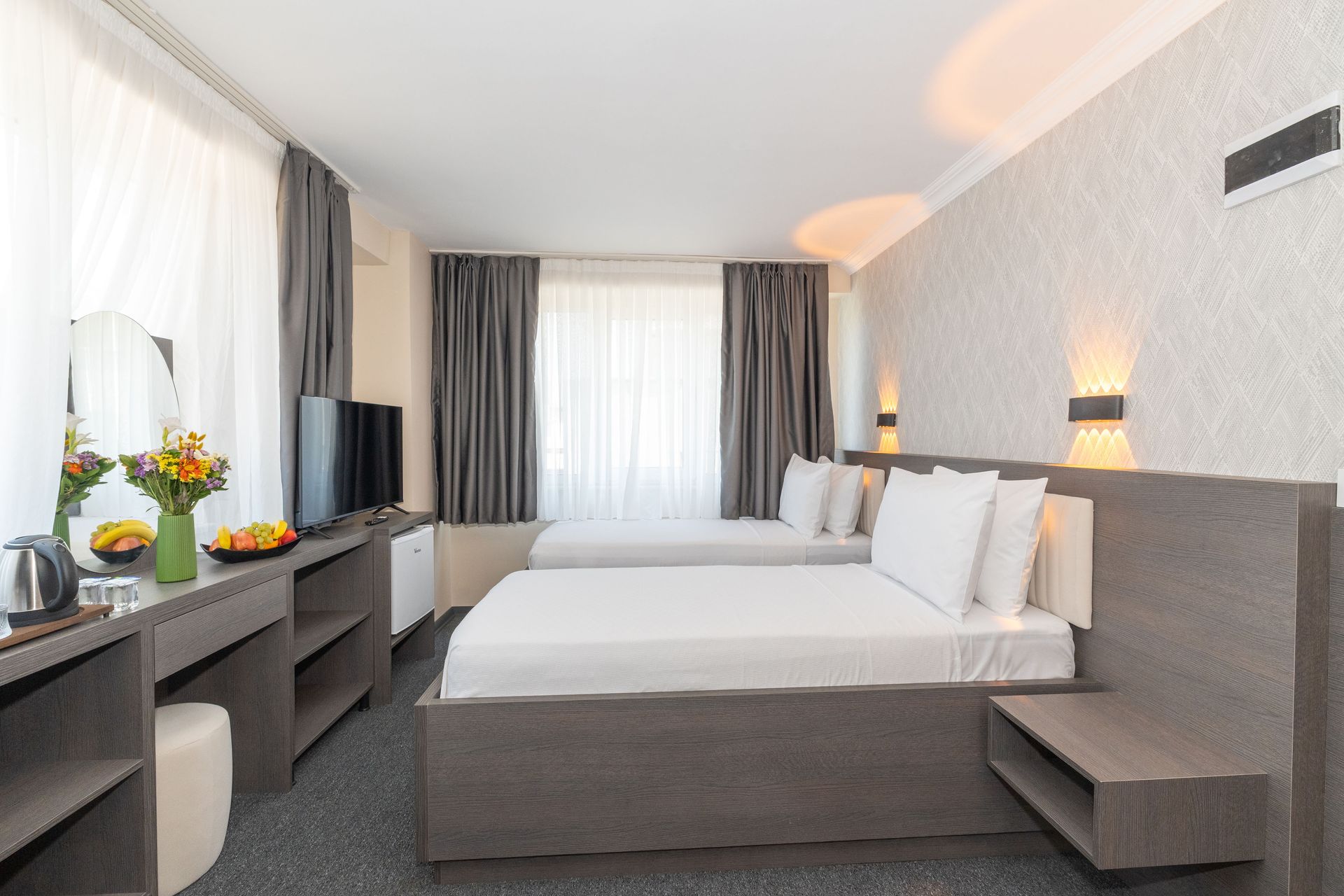 Istanbul By Rich Hotel |Twin Room | Hotel room with two twin beds, desk, TV, and gray decor.