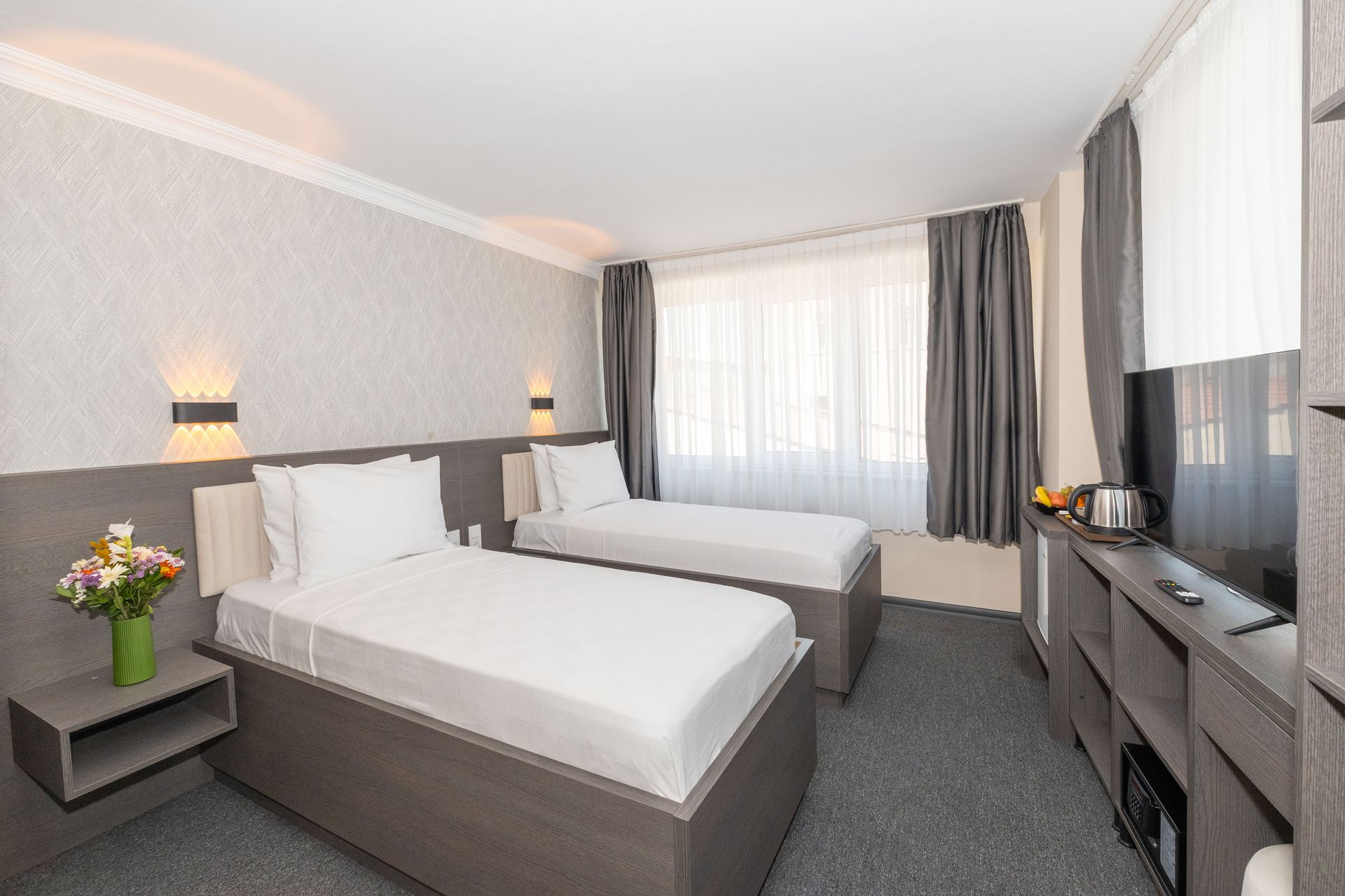 Istanbul By Rich Hotel | A hotel room with two beds, a window with curtains, and a television.