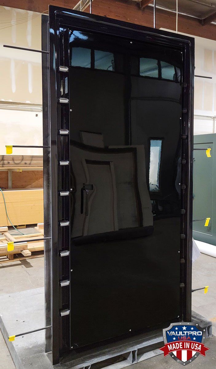A large black glass door is sitting on top of a pallet.