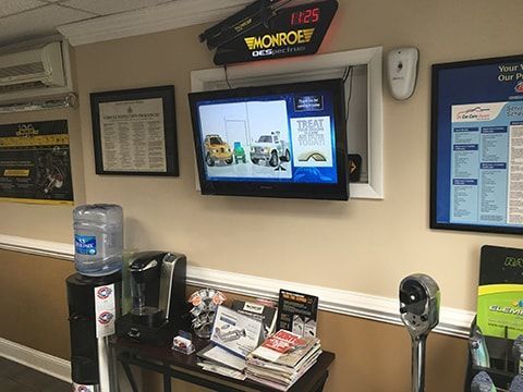 Waiting room: TV playing car ad, water cooler, coffee maker, magazines on a small table. | Auto Clinic Care