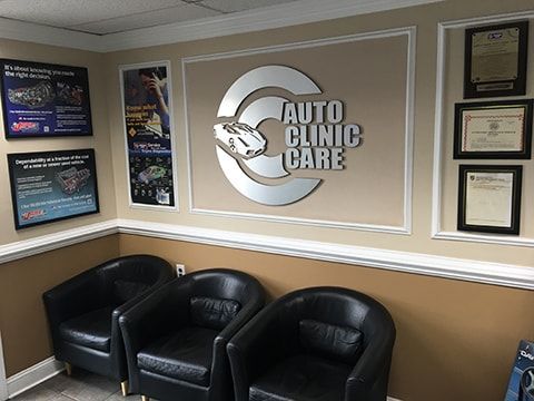 Waiting area of "Auto Clinic Care" with three black leather chairs and logo. | Auto Clinic Care