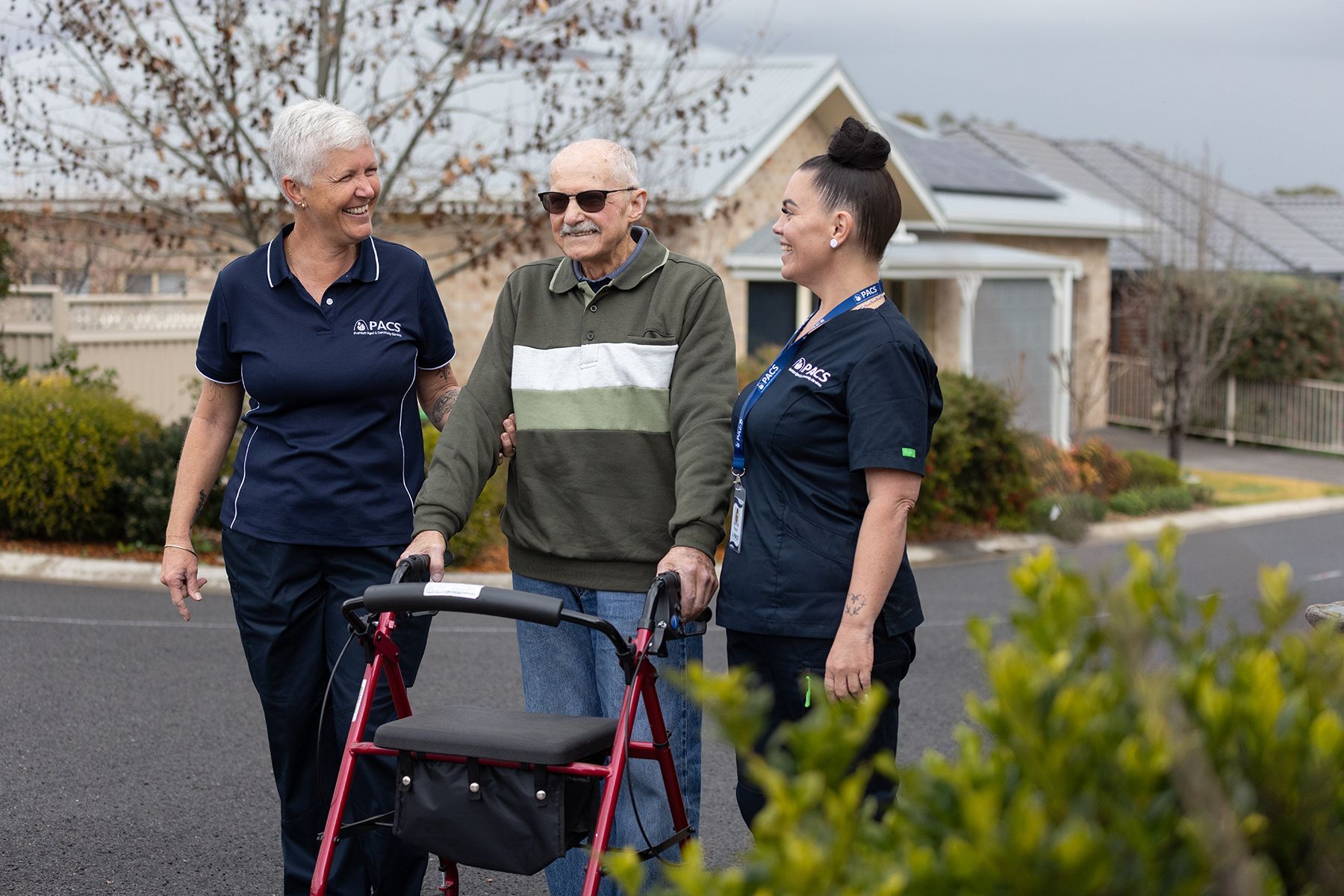 Woman in a Blue Shirt Points at Something in a Book While Sitting — Premium Aged & Community Services In Tamworth, NSW