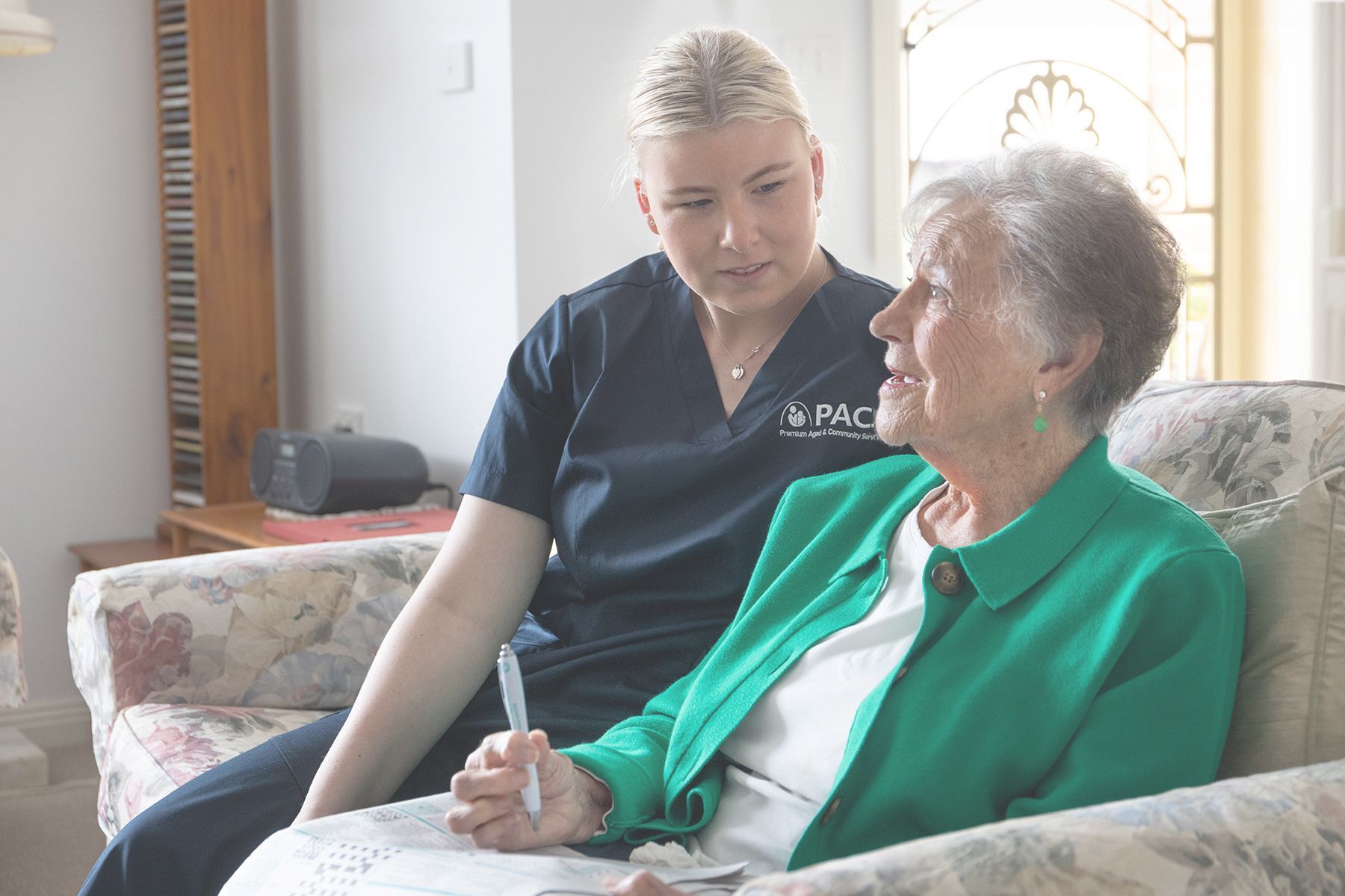 Woman in Navy Top Assists Older Woman in Green Jacket — Premium Aged & Community Services In Tamworth, NSW