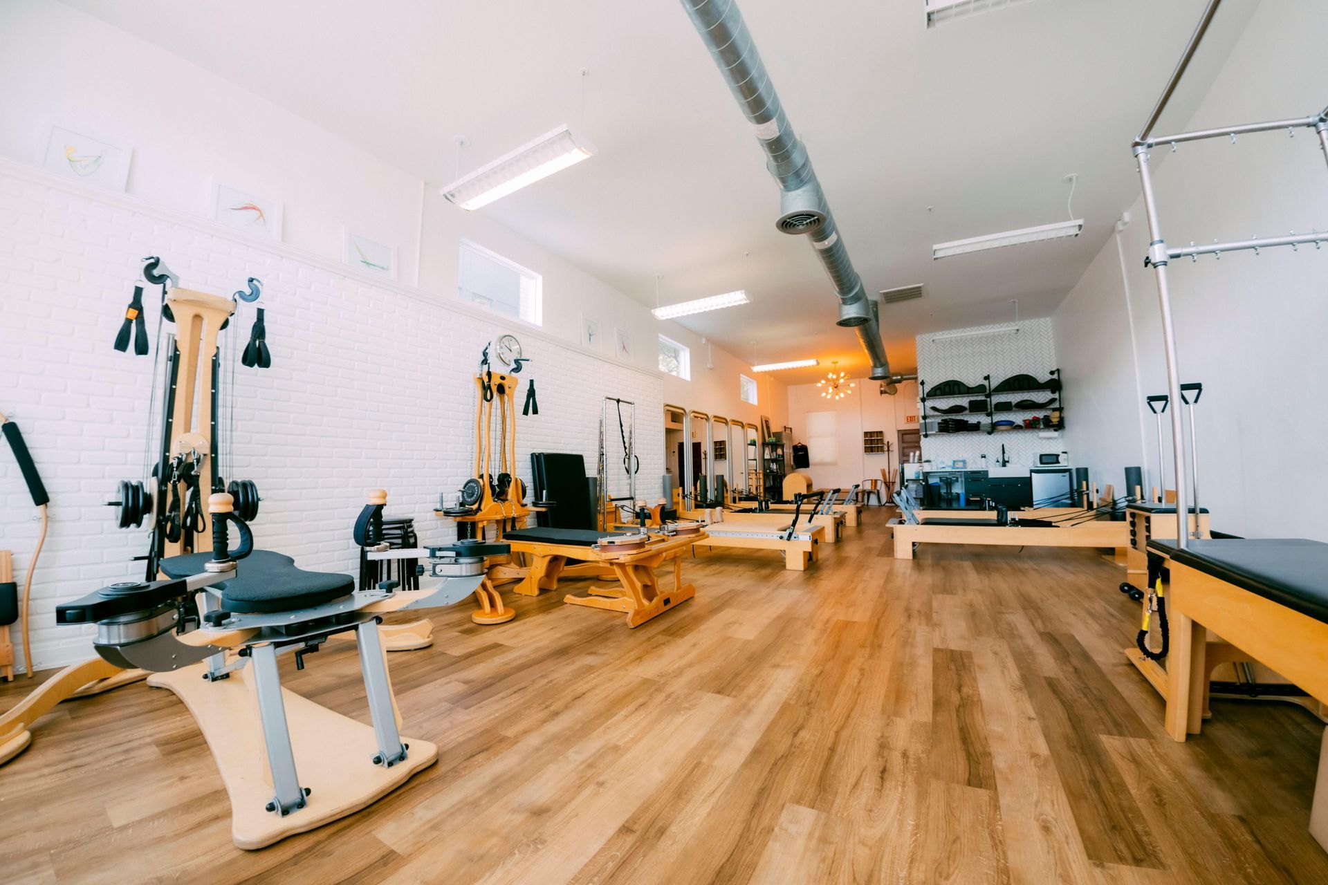 A large room filled with lots of exercise equipment in a pilates studio.