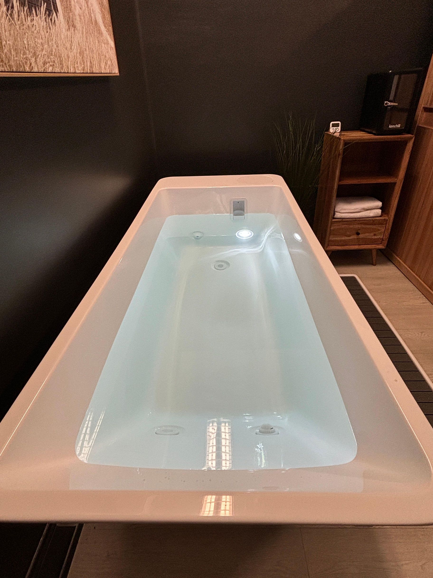 A bathtub filled with water is sitting on a table in a bathroom.