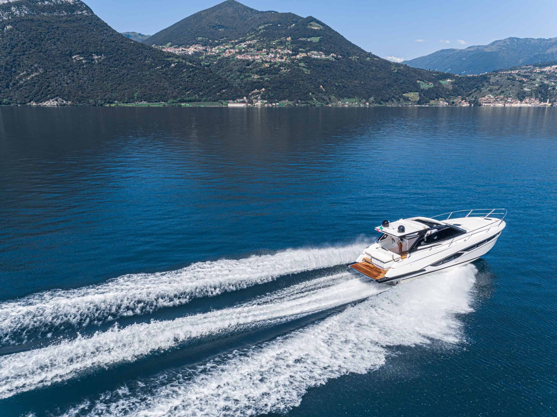 A boat is floating on top of a lake with mountains in the background.