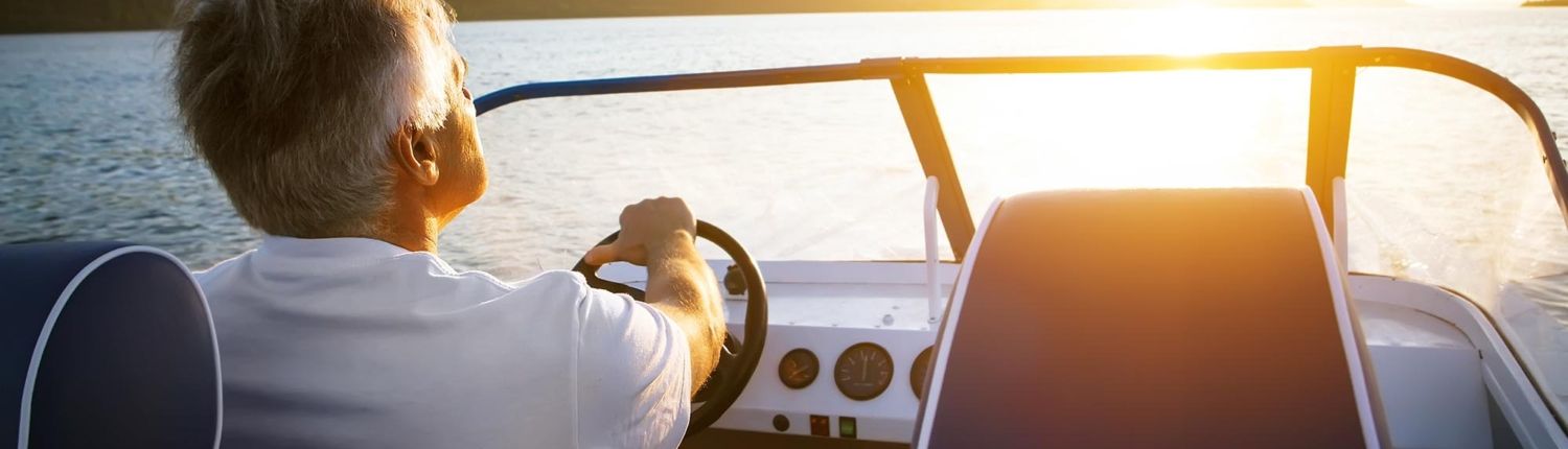 Back view of a man driving a boat on a lake