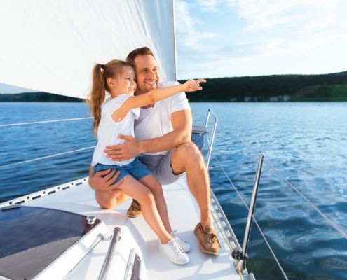 Father sitting with daughter on boat.