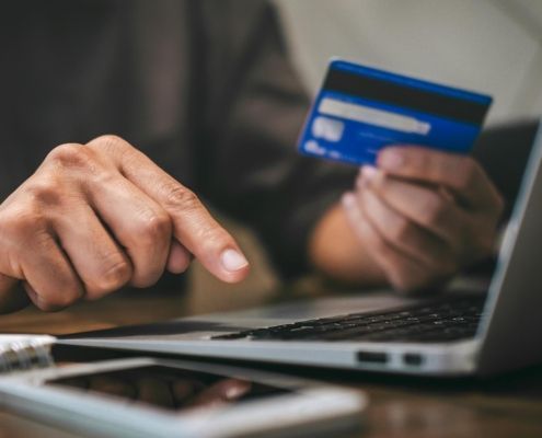 Image of a person making an online payment, using their credit card.