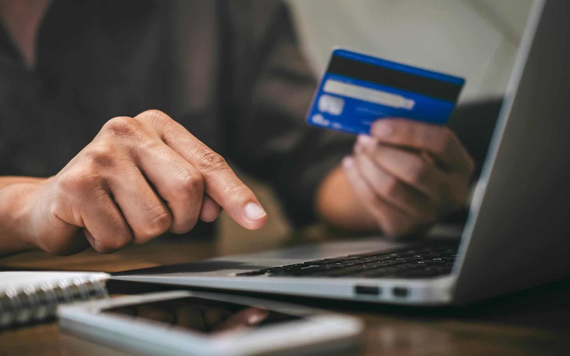 Image of a person making an online payment, using their credit card.