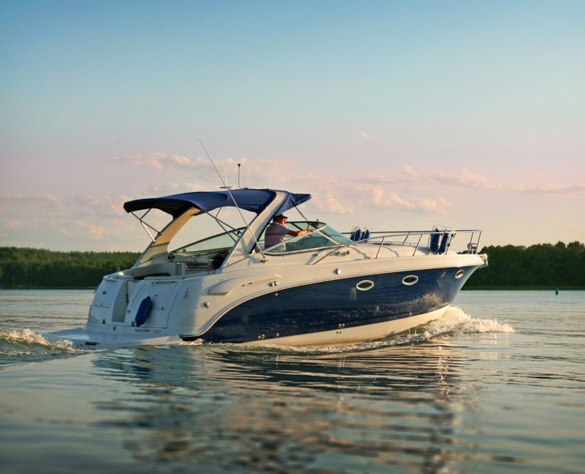 A blue and white boat is floating on top of a lake.