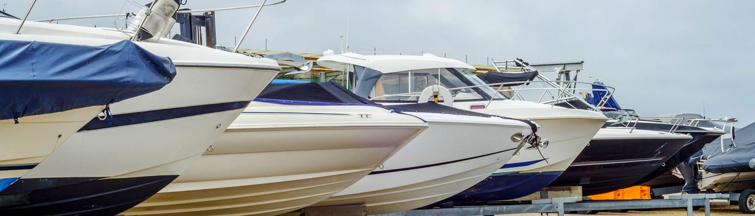 A row of boats are parked next to each other in a marina.