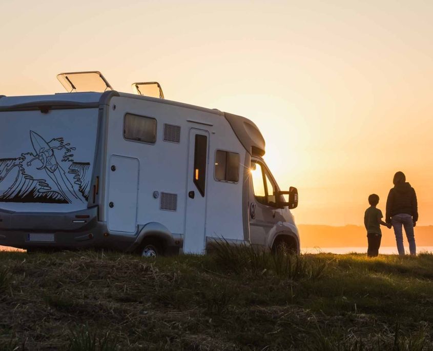 woman with child looking at the sunset by the rv_