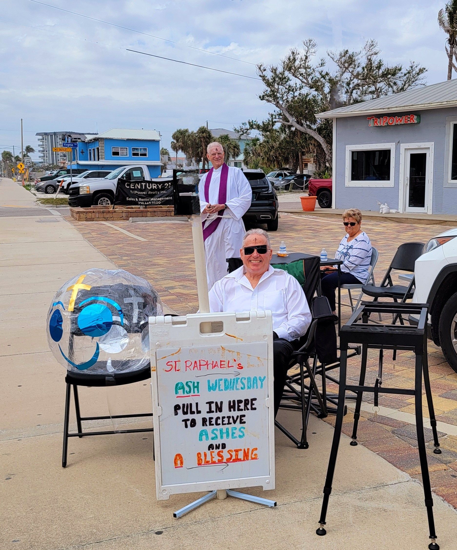 Three people with a sign: 