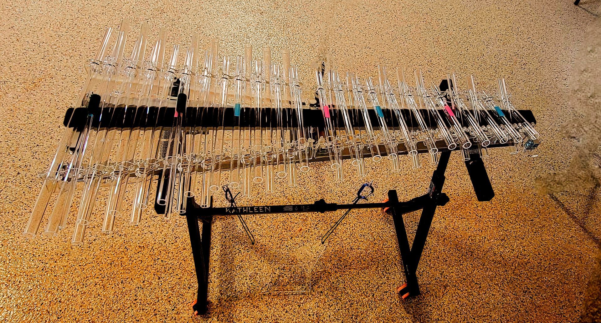 A glass marimba on a black stand with rows of glass keys.
