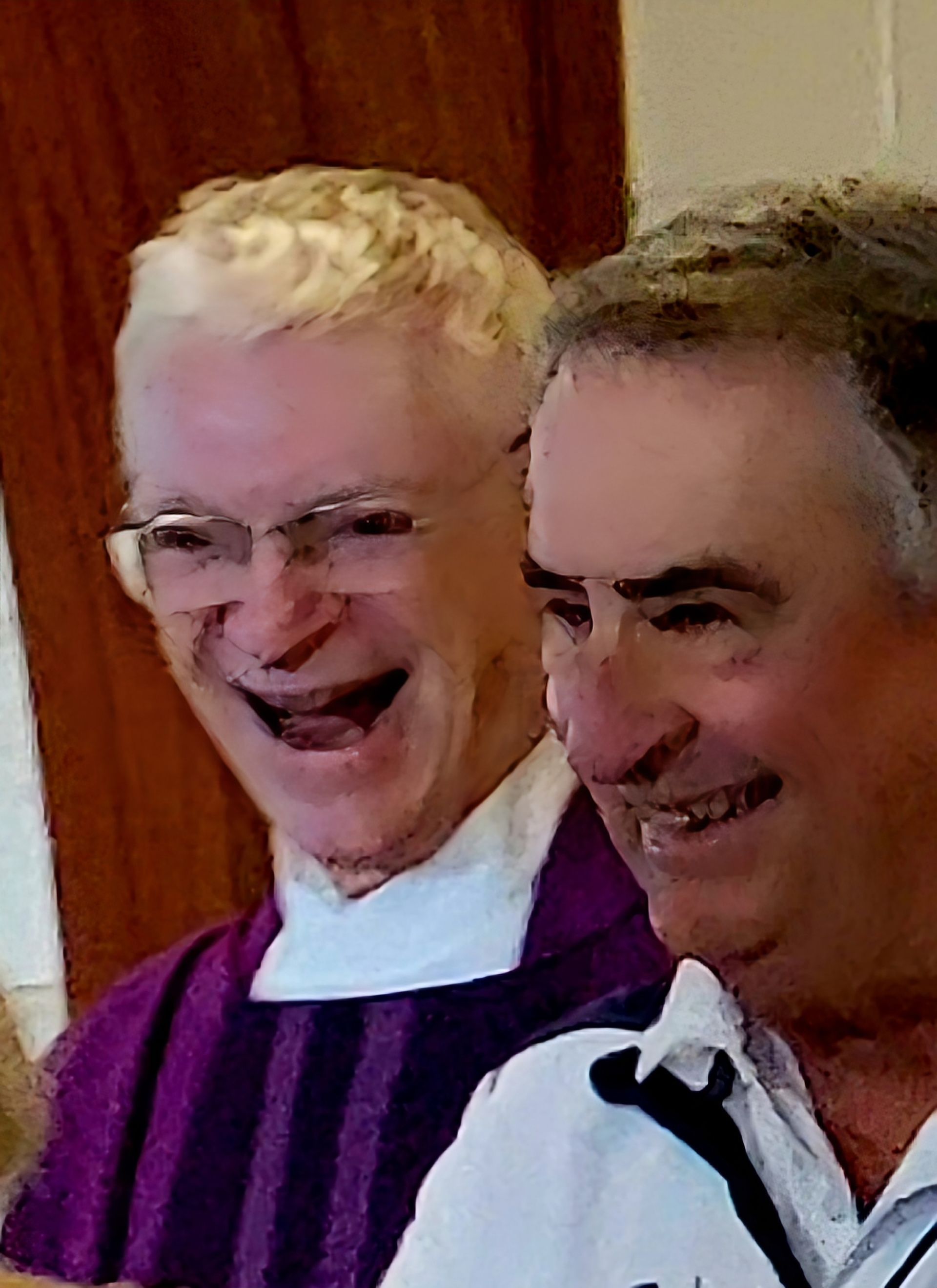Two men laughing; one in purple clergy attire, the other in a white shirt.