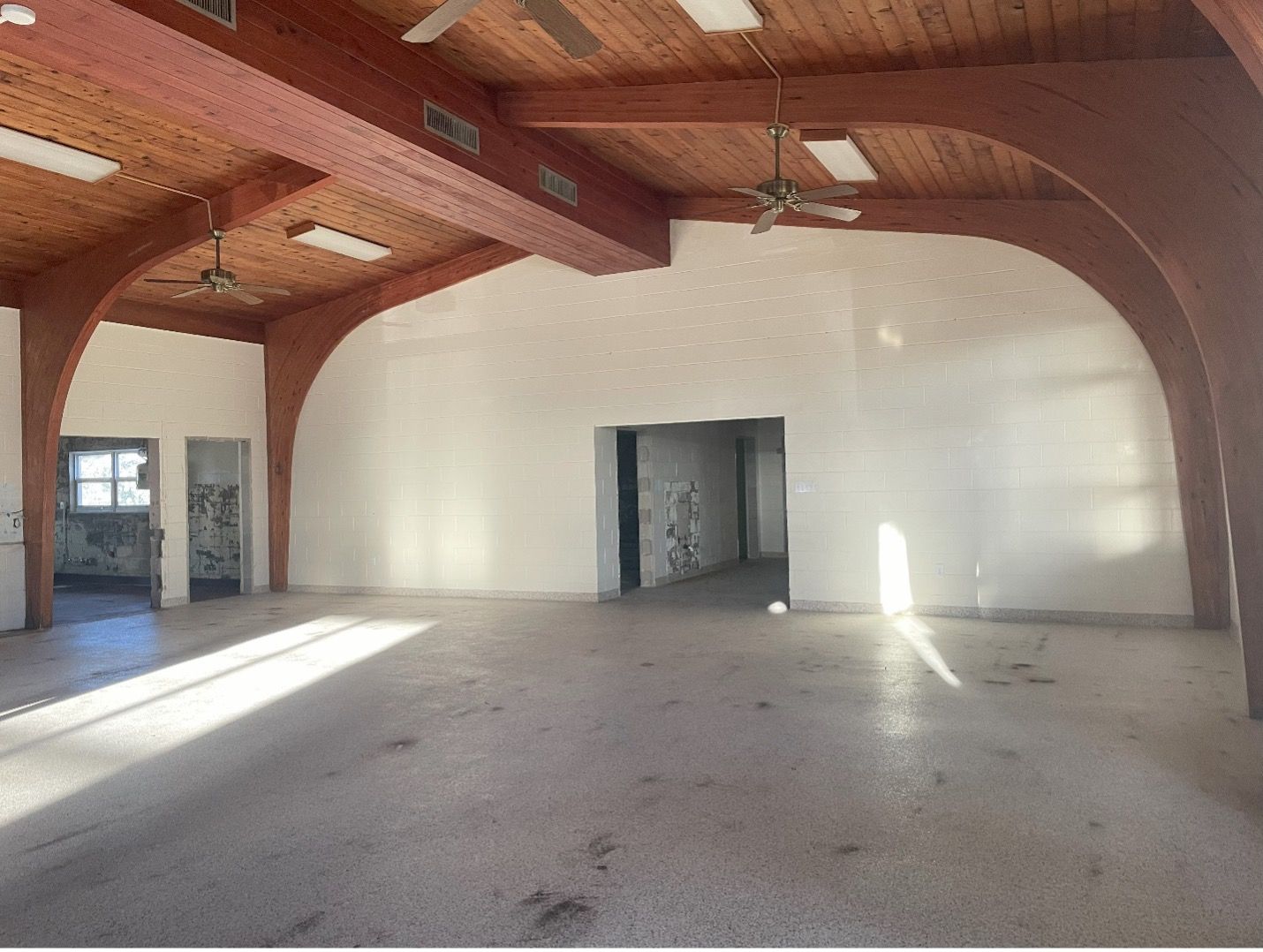 A large empty room with a wooden ceiling and white walls