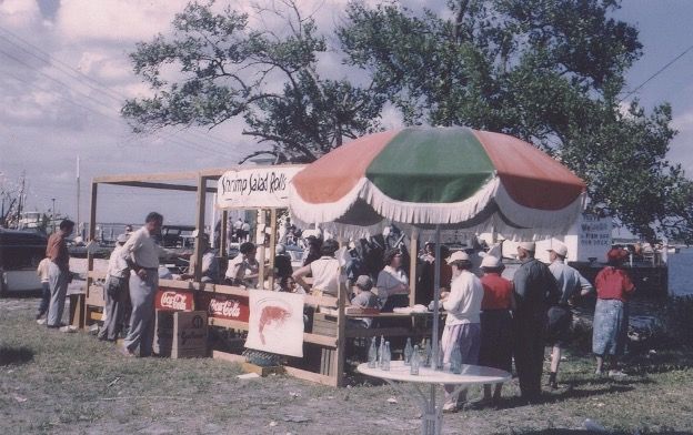 A group of people are gathered around a coca cola stand