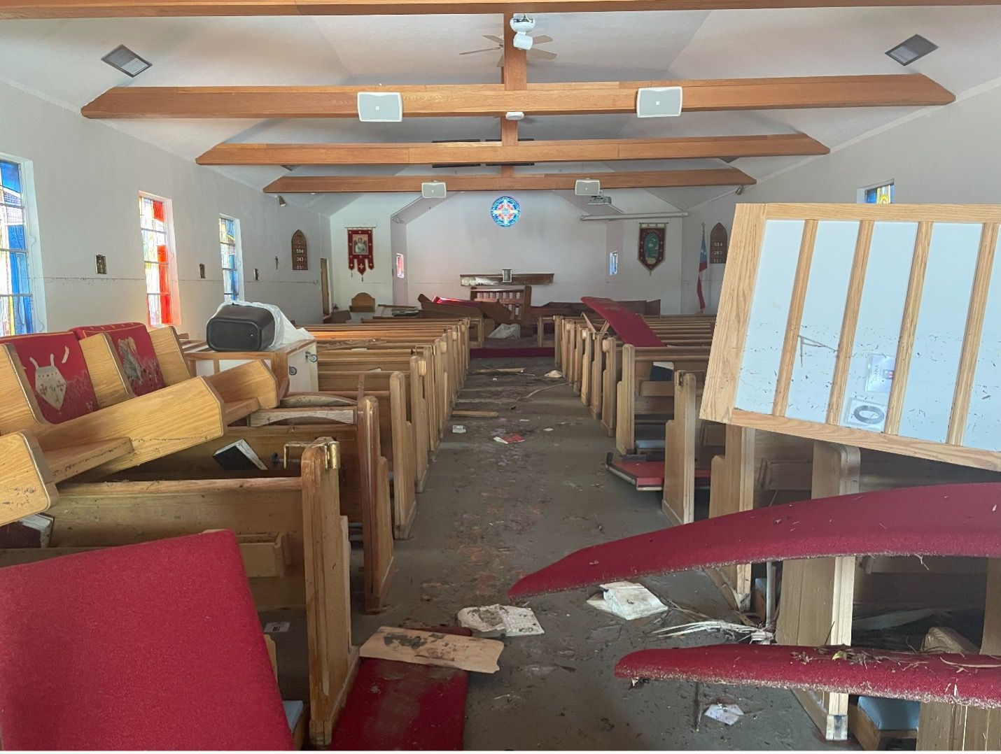 The inside of an abandoned church with a lot of furniture laying on the floor