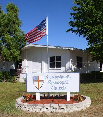 A sign for st. raphael 's episcopal church with an american flag in the background