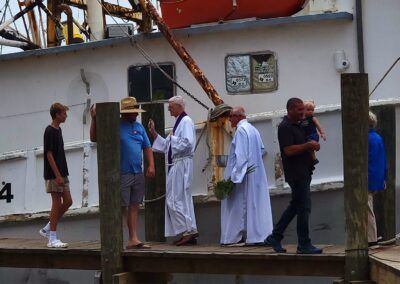 A group of people standing on a dock next to a boat with the number 4 on it