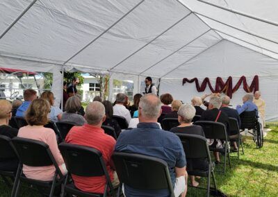 A group of people are sitting under a tent.