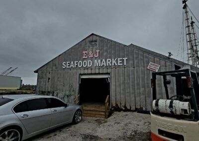 A car is parked in front of a building that says e & j seafood market.