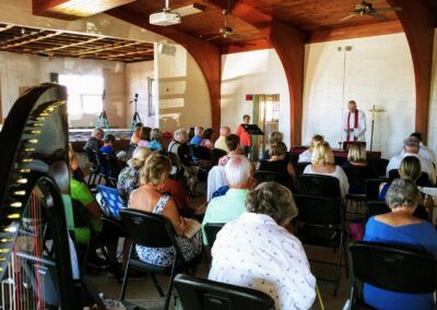 A large group of people are sitting in chairs in a church.