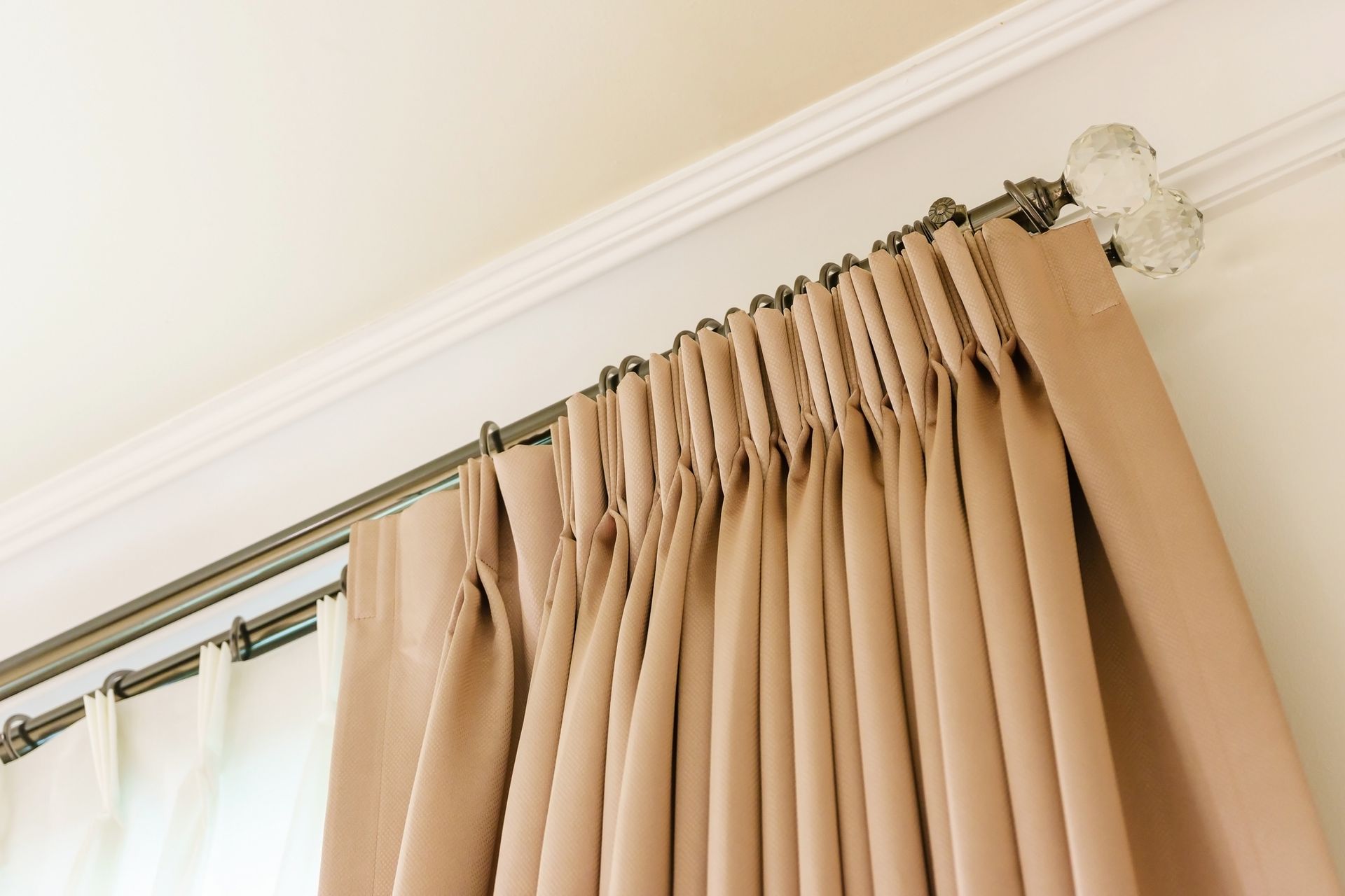 A close up of a pair of curtains hanging from the ceiling