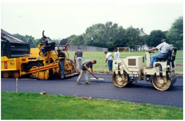 Line Striping — Workers Filling Road With Asphalt in Rocky Hill, CT