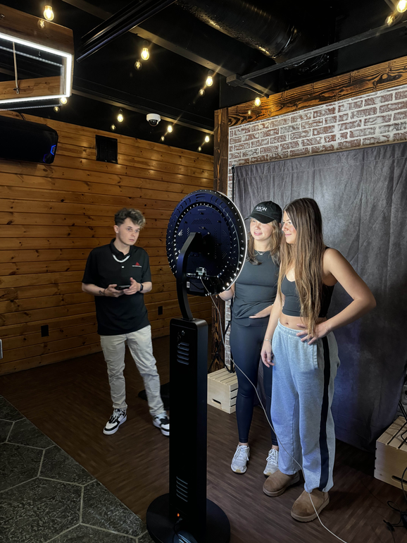 A group of people are standing in front of a photo booth.