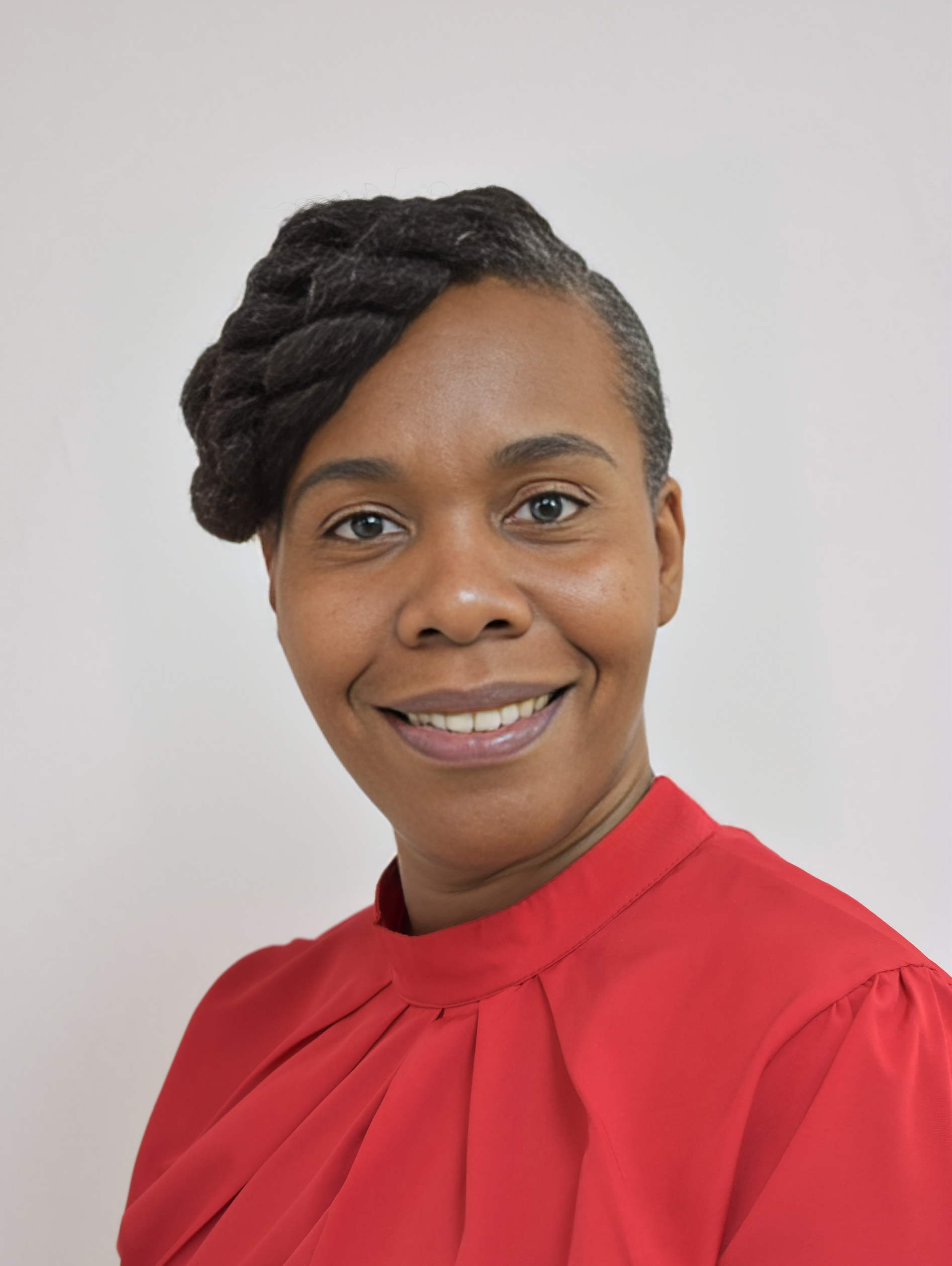 A woman in a red shirt is smiling for the camera