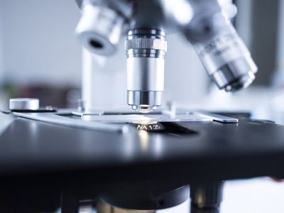 A close up of a microscope in a laboratory.