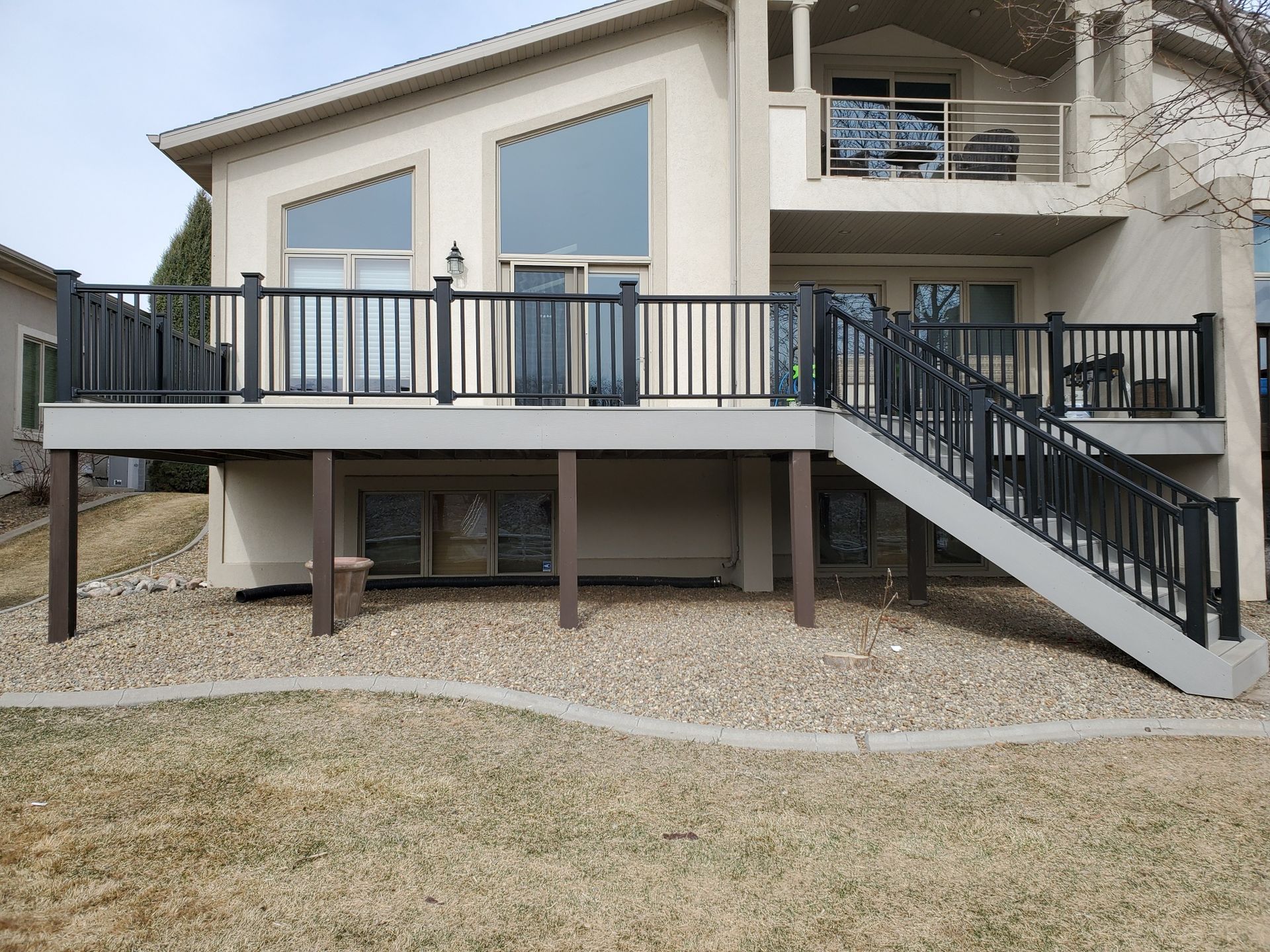 A large house with a large deck and stairs leading up to it.