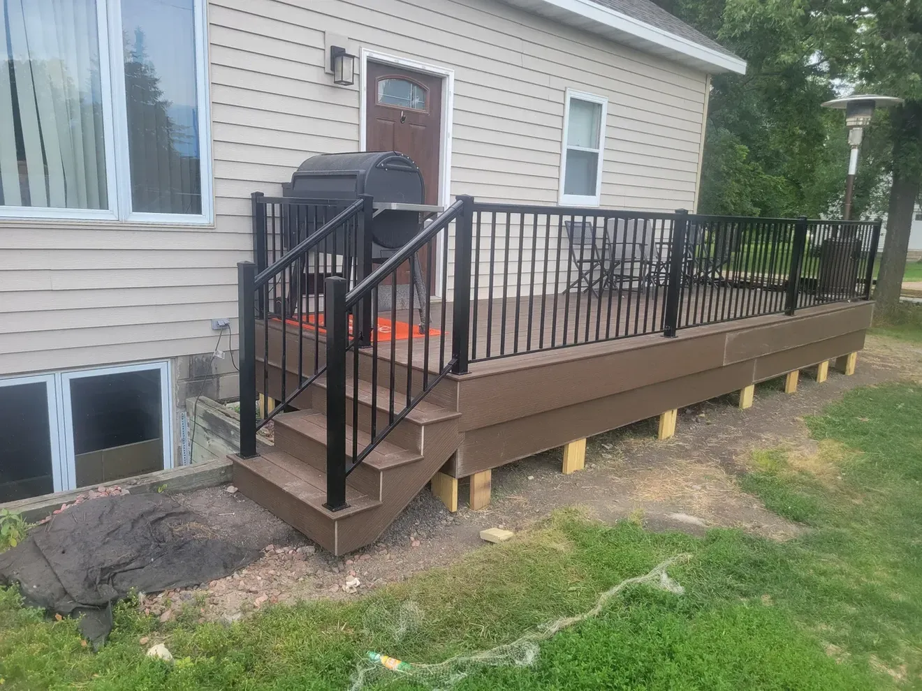 A house with a deck and stairs in front of it.