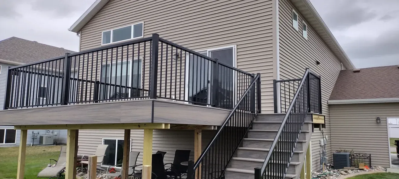 A large house with a large deck and stairs leading up to it.
