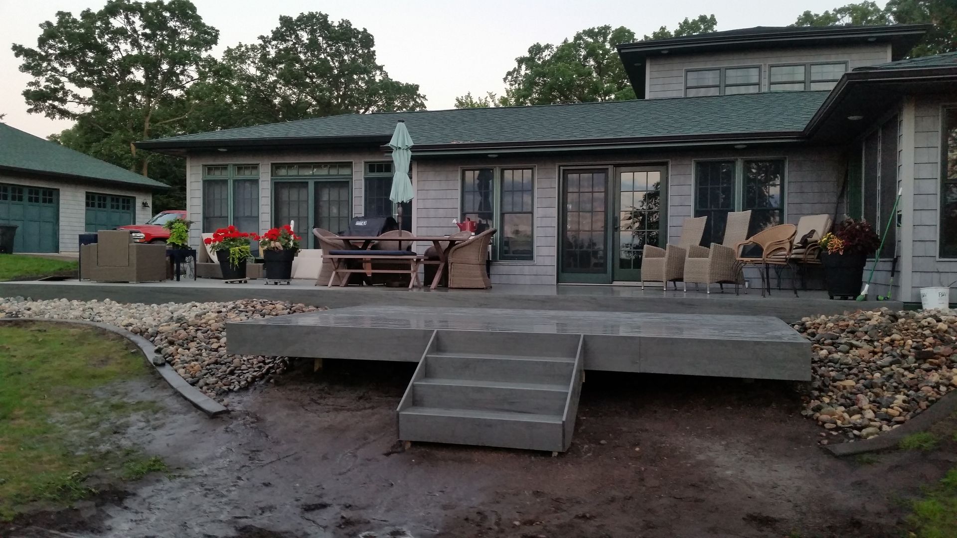 A house with a concrete deck and stairs in front of it