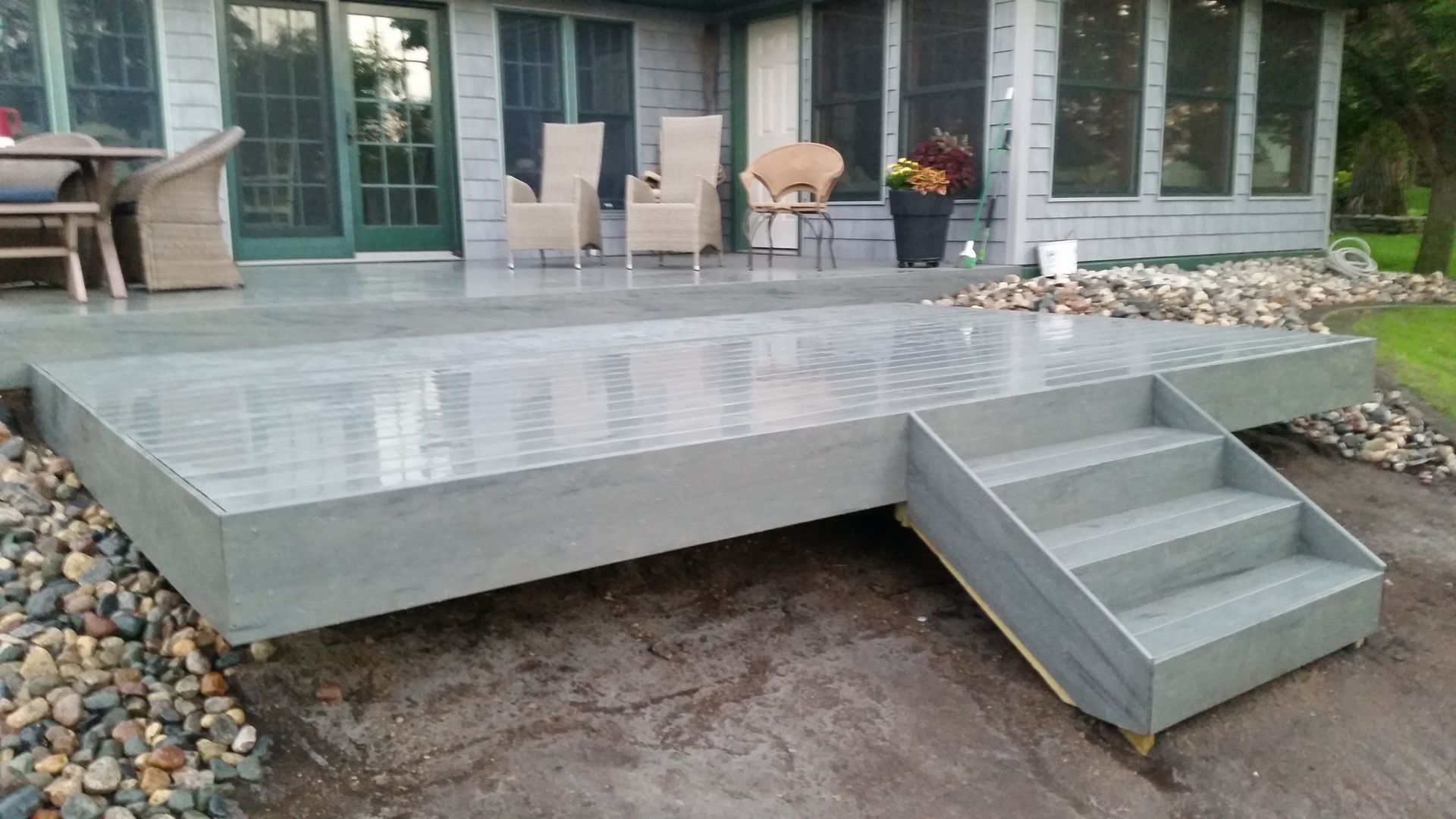 A concrete deck with stairs in front of a house