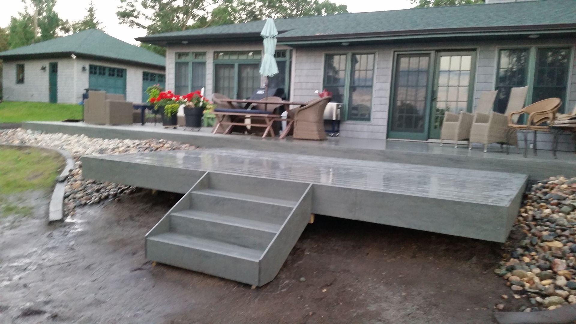 A concrete deck with stairs in front of a house