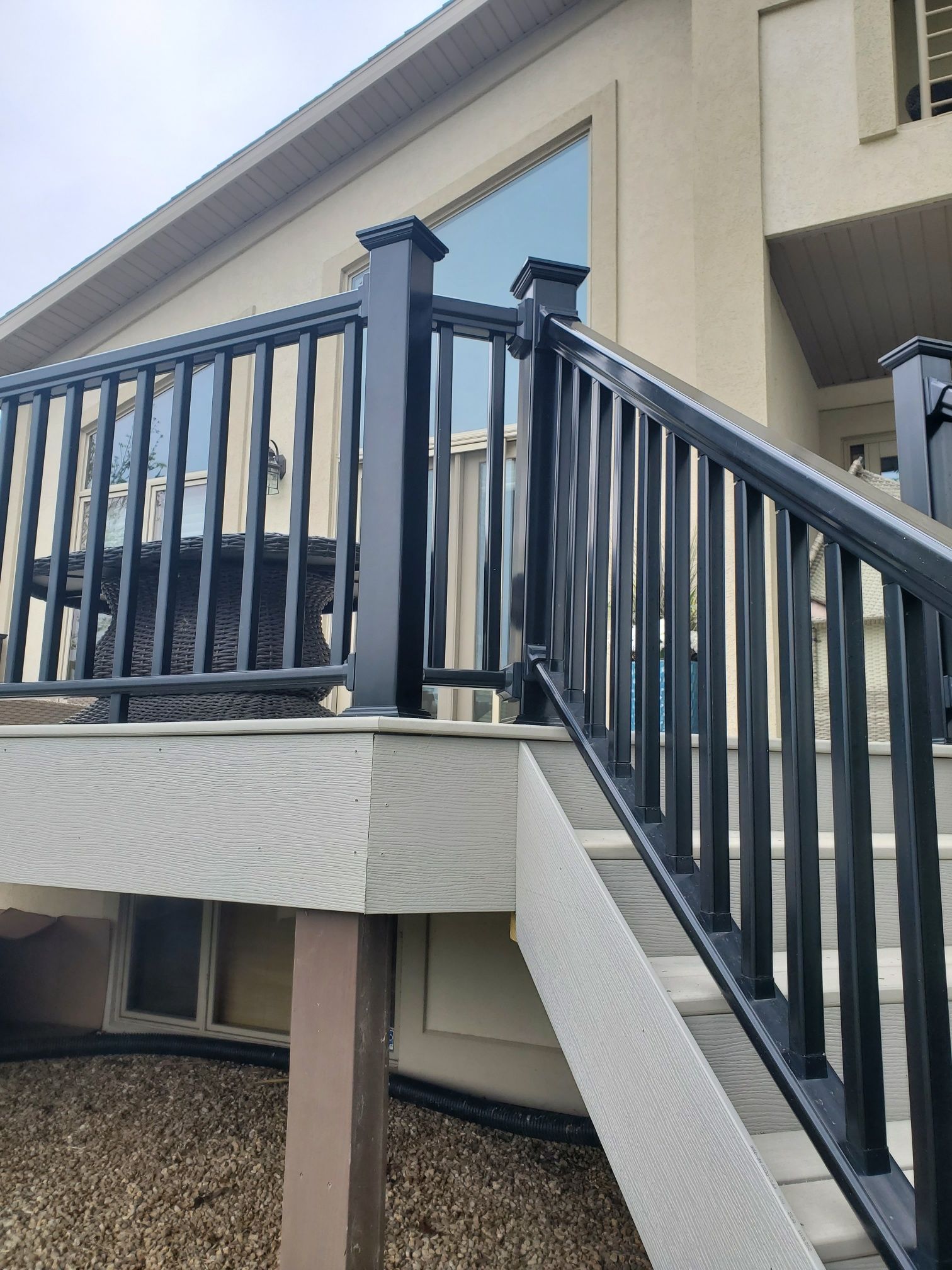 Stairs leading up to a deck with a black railing