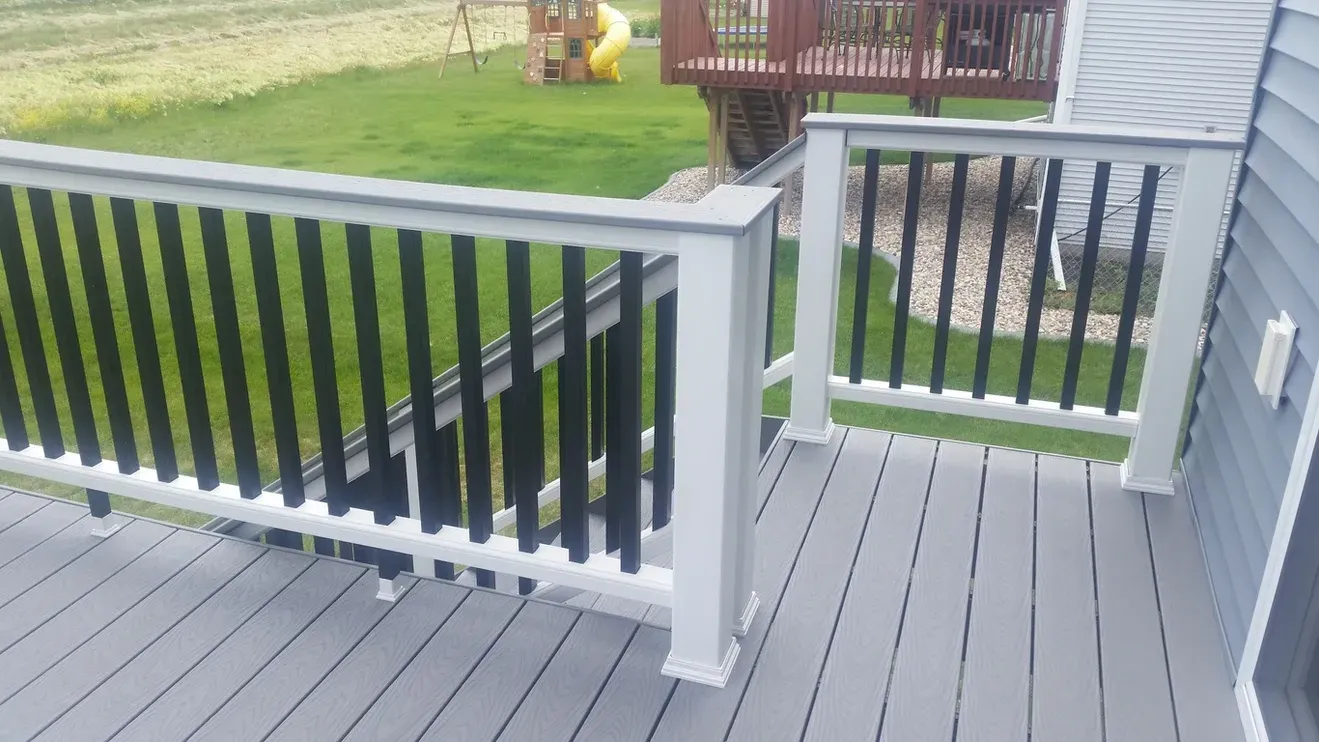 A deck with a black railing and a white railing.