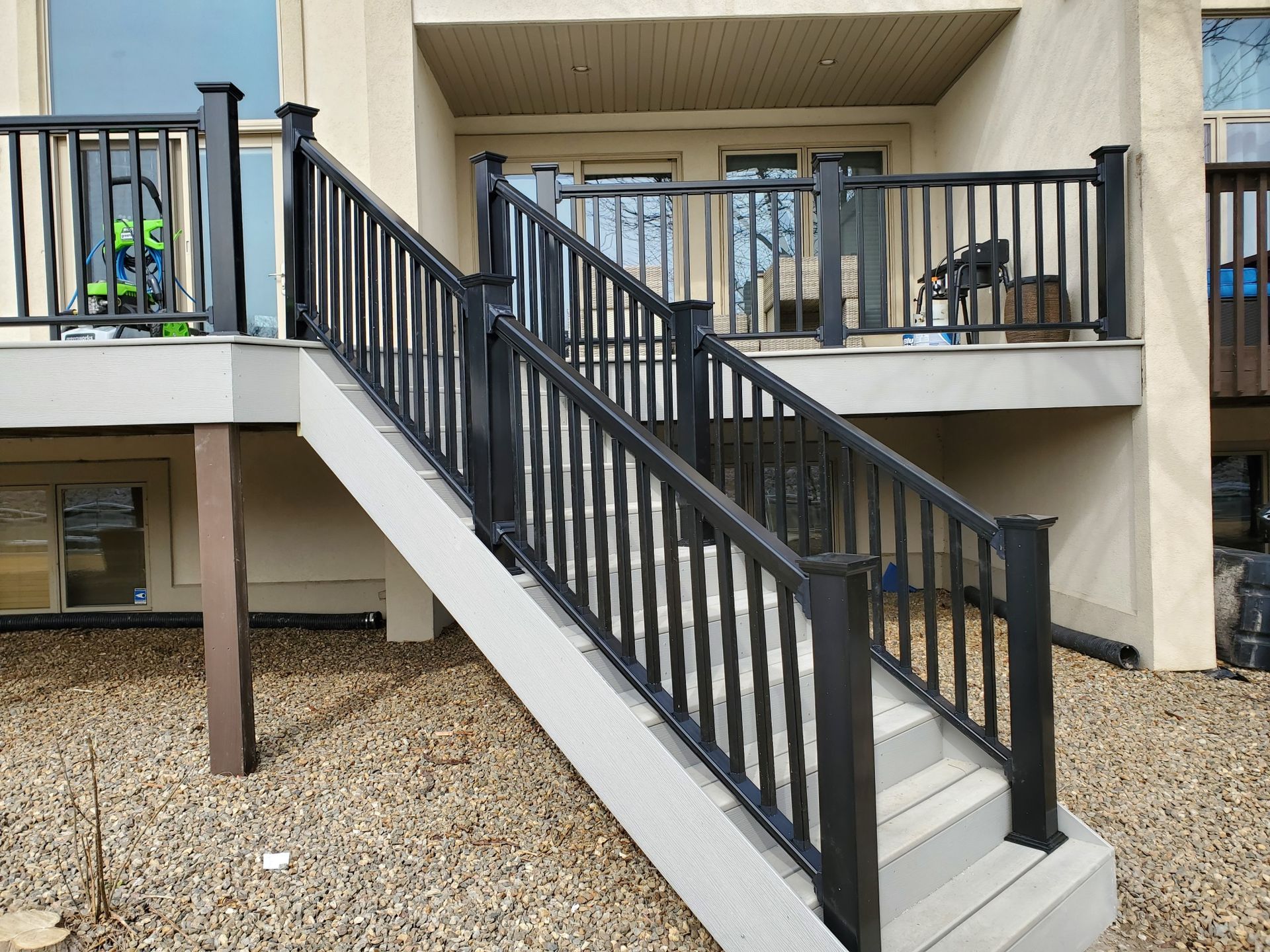 Stairs leading up to a deck with a black railing