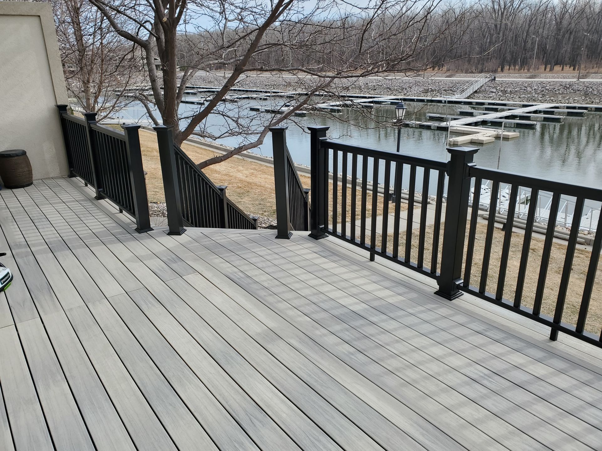A deck with a black railing overlooking a body of water.