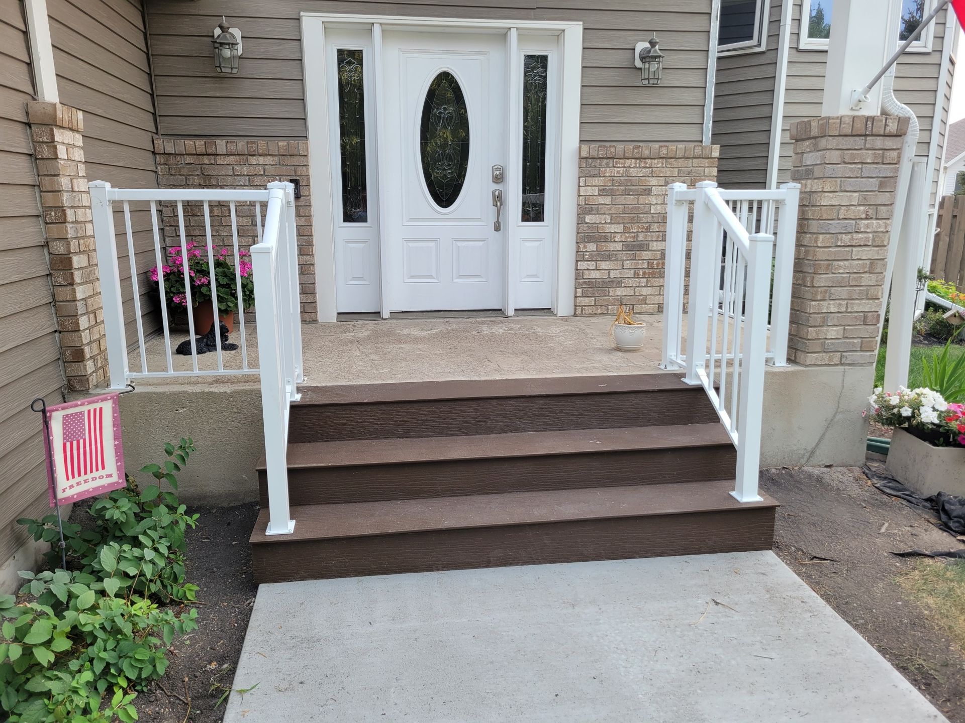 The front of a house with stairs and a white railing