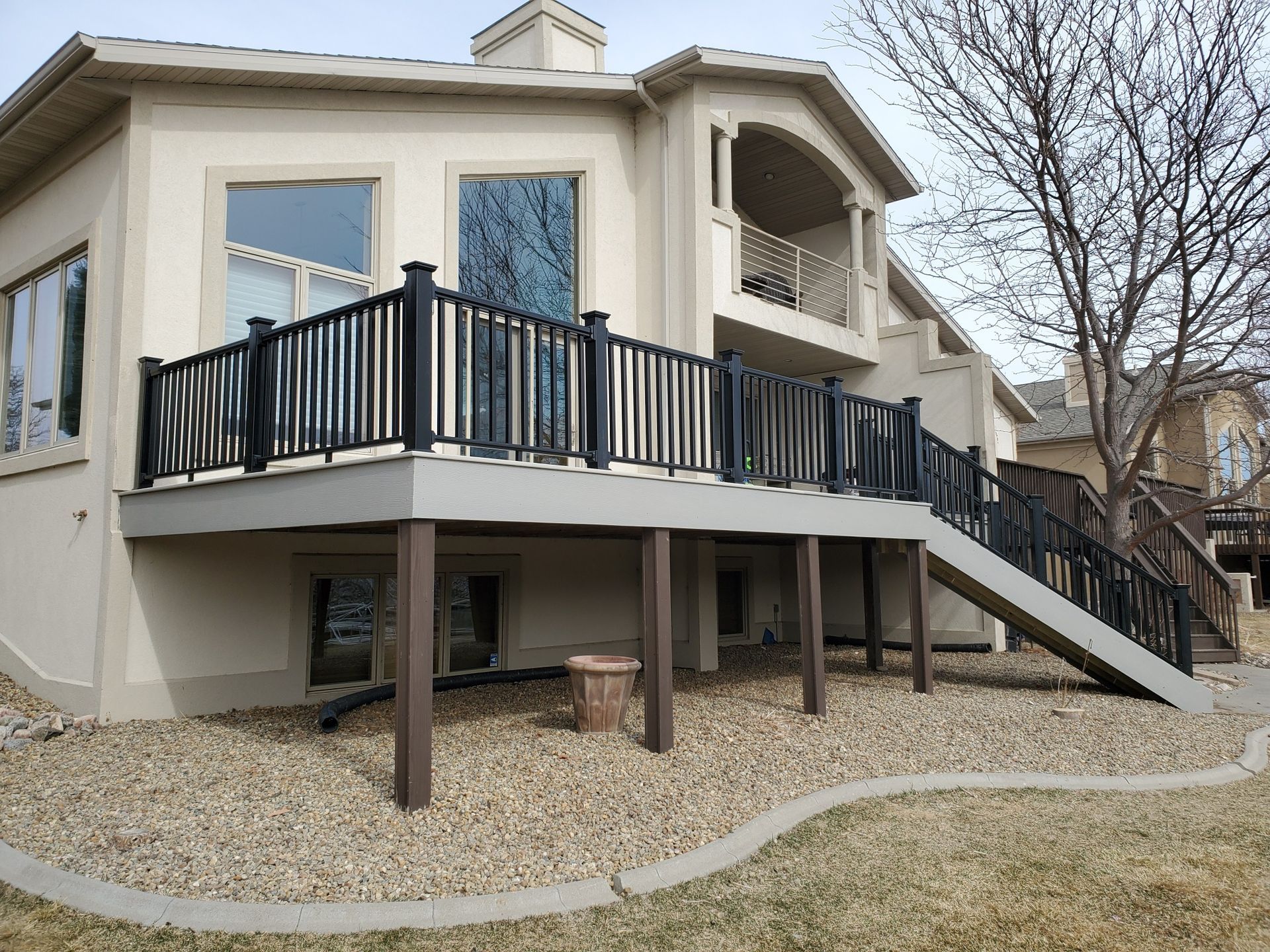 A large house with a large deck and stairs leading up to it.
