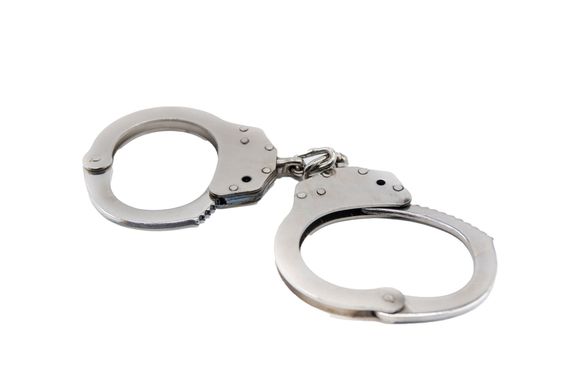 A pair of handcuffs on a white background. A pair of handcuffs on a white background.