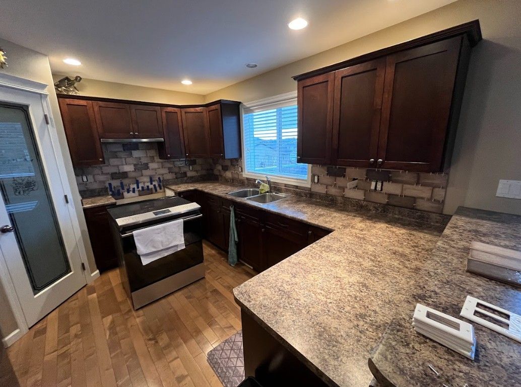 Kitchen with dark wood cabinets, granite countertops, and stainless steel appliances.